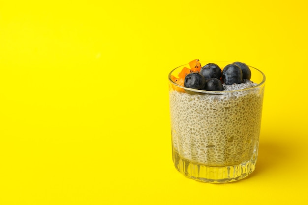 Verre de délicieux pudding de chia sur fond jaune