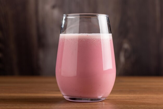 Verre avec un délicieux smoothie aux fraises