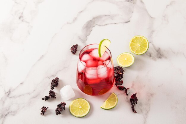 Un verre de délicieux thé glacé sain à partir d'hibiscus de pétales de rose avec un antiseptique antiseptique antibiotique naturel à la chaux le concept de perte de poids