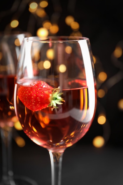 Verre de délicieux vin de fraise contre les lumières floues