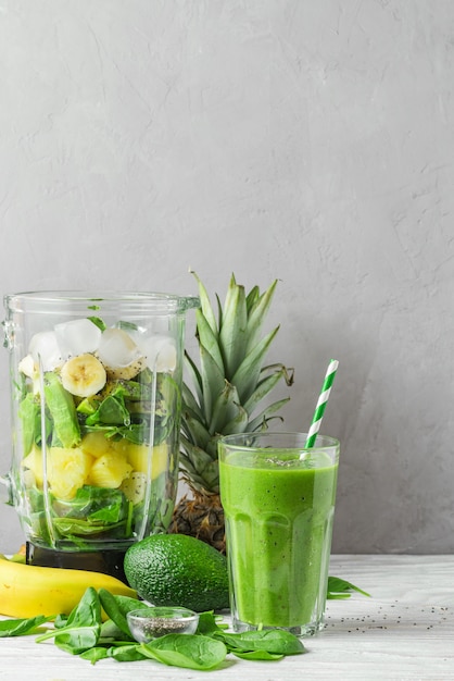 Verre de détox de smoothie vert avec des ingrédients juteux frais dans un mélangeur pour préparer une boisson saine. concept de cuisine végétalienne