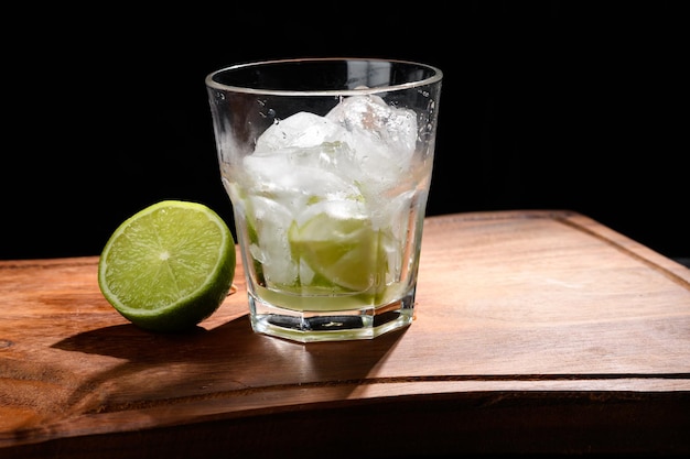 un verre avec du citron et de la glace pour boire un verre sur fond noir