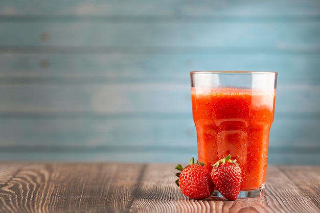 Verre avec du jus de fraise sur la table