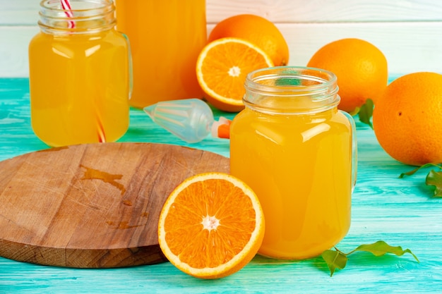 Verre avec du jus d'orange sur une table en bois verte