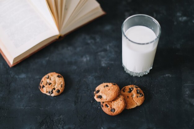 Photo verre avec du lait frais et des biscuits à l'avoine au chocolat pour le petit déjeuner