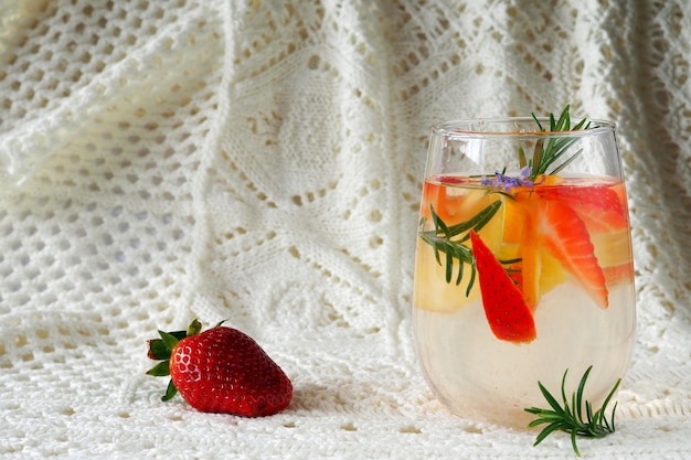 Un verre avec de l'eau aromatisée aux fraises oranges