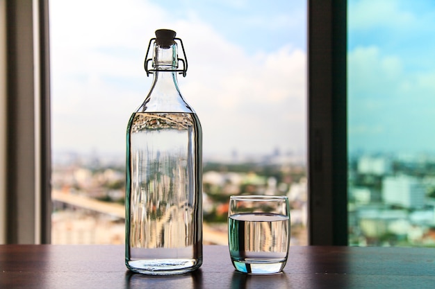 Verre d&#39;eau avec une bouteille sur table