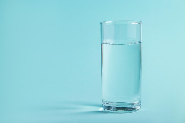 Un verre d'eau claire sur un fond bleu Concept de santé lieu pour le texte