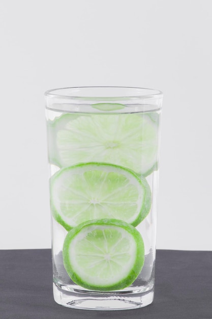 Verre avec de l'eau et du citron isolé sur fond blanc