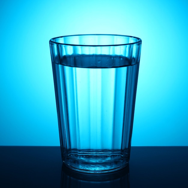 Un verre d'eau sur fond bleu