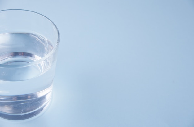 Verre avec de l&#39;eau sur un fond bleu