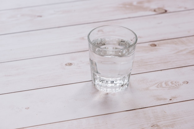 Verre d'eau sur fond de table en bois