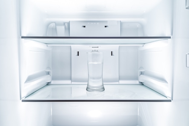 Verre d'eau froide dans un réfrigérateur propre