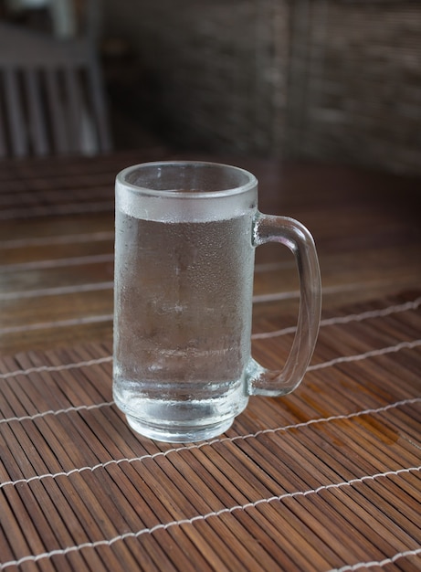 Verre d'eau froide sur table en bois