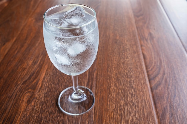 Verre avec de l'eau et de la glace sur la table