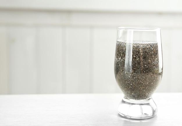 Verre d'eau avec graines de chia sur table