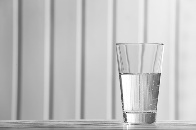 Verre d'eau minérale propre sur la surface en bois de couleur ancienne et fond de planches