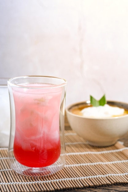 un verre d'eau de noix de coco avec du sirop rouge sur une table en bois repas de l'iftar du Ramadan