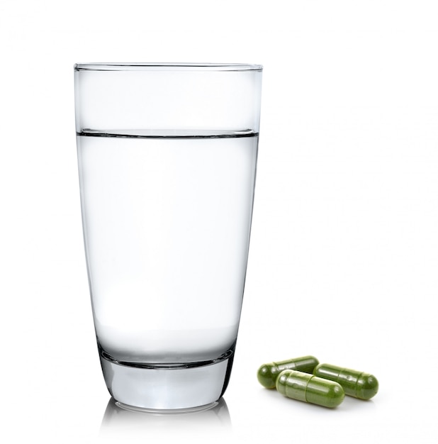 Verre d'eau et pilules de capsule de moringa