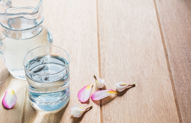 Verre à eau avec pot en verre sur table en bois. Verre et eau potable avec copie espace.