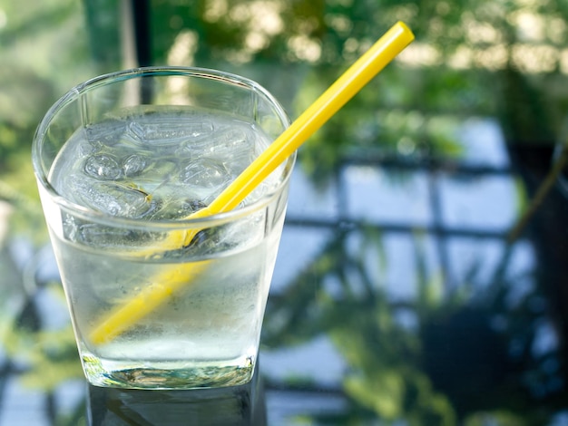 Un verre d'eau potable froide avec de la paille jaune