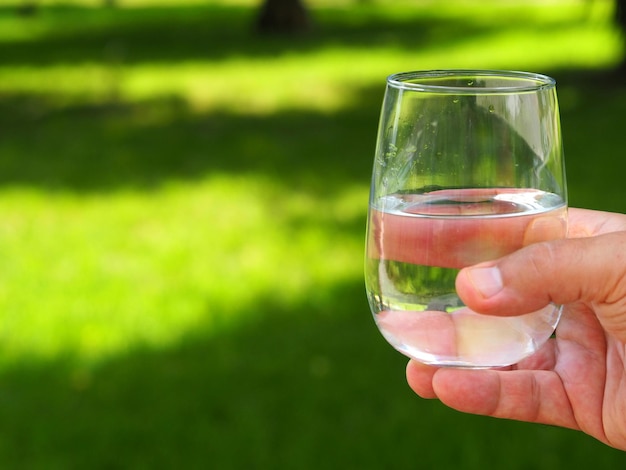 Verre avec de l'eau potable à la main