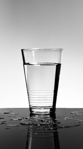 Verre à eau avec reflet sur le sol en verre