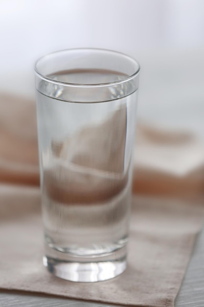 Verre d'eau avec serviette sur fond de bois