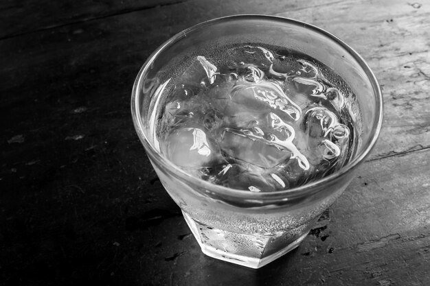 Verre d&#39;eau sur la table en bois.