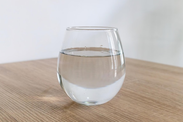 Un verre d'eau sur une table en bois.