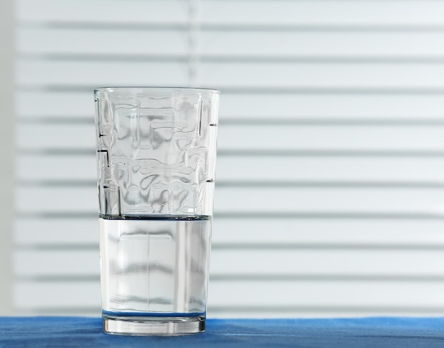 Verre d'eau sur table sur fond clair