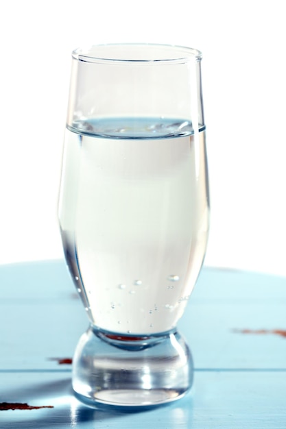 Verre d'eau sur table sur fond clair