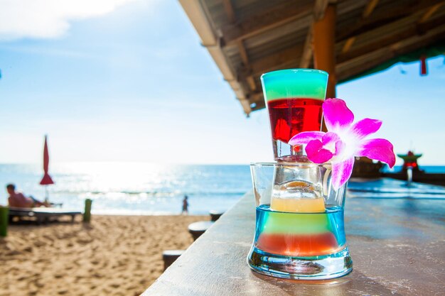 Un verre d'eau sur la table par la mer contre le ciel