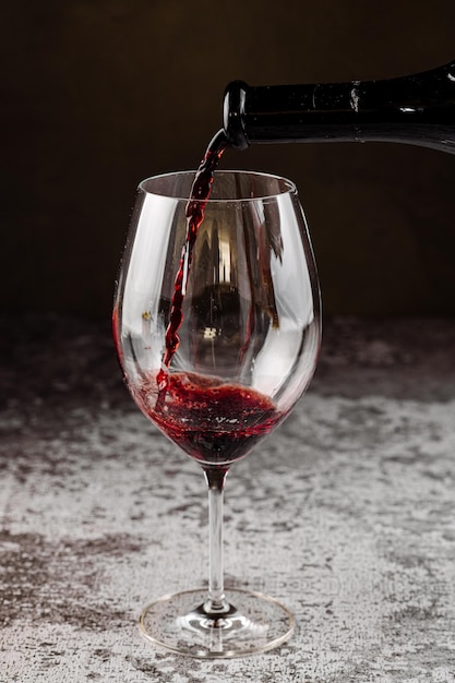 Verre élégant avec du vin rouge sur fond noir