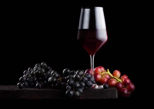 Verre élégant de vin rouge avec des raisins noirs et rouges