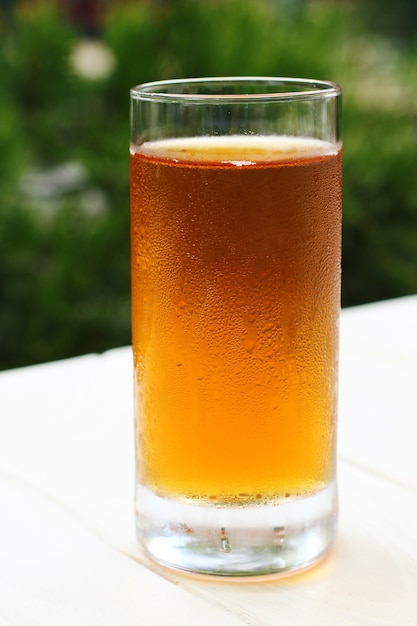 Verre embué avec du jus sur la terrasse d'été. Photographie en gros plan, prise de vue macro.