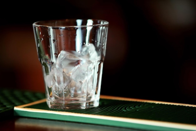 Verre avec de la glace sur le comptoir du bar