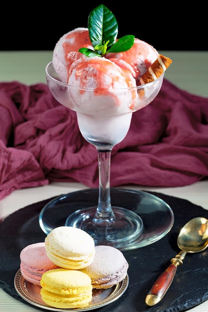 Un verre de glace à la fraise avec un verre de glace sur un plateau.