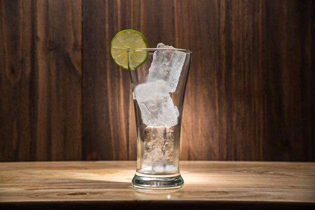 Verre avec de la glace sur la table en bois