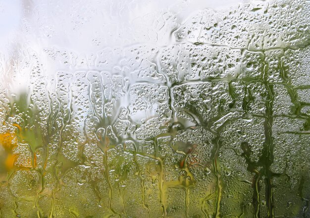 Verre humide avec des gouttes de pluie sur fond de nature.