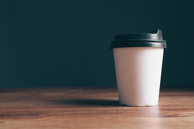 Verre jetable pour le café sur fond gris