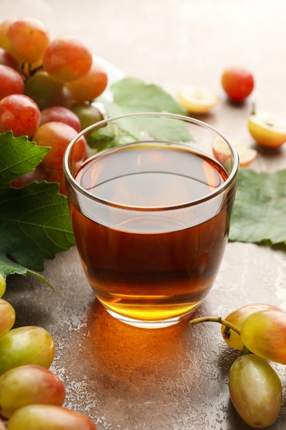 Verre de jus et assiette de raisin sur gris