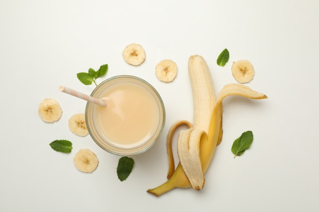 Verre de jus de banane frais sur blanc