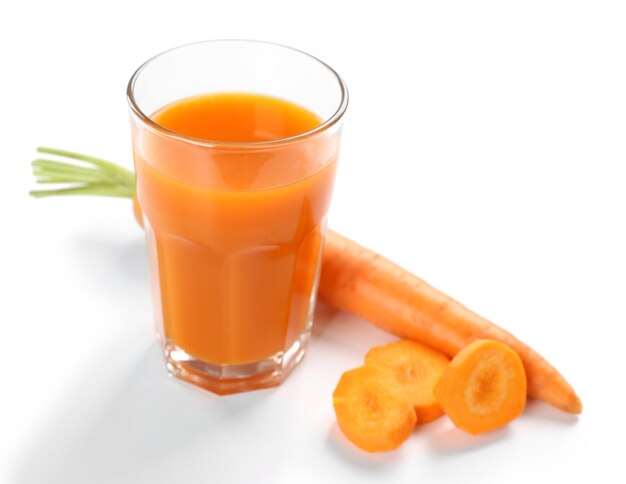 Verre de jus de carotte avec des tranches de légumes avec des légumes isolés sur blanc