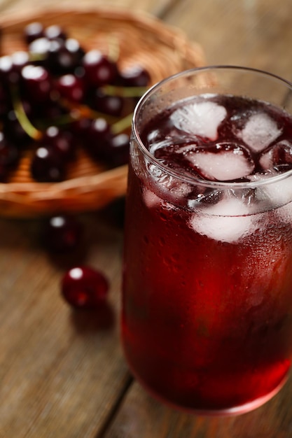 Verre de jus de cerise sur table en bois libre