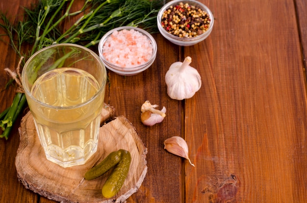 Photo verre à jus de cornichon, concombre mariné sur bois