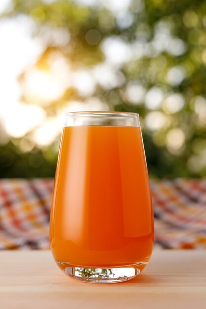 Le verre de jus dans un jardin La table en bois