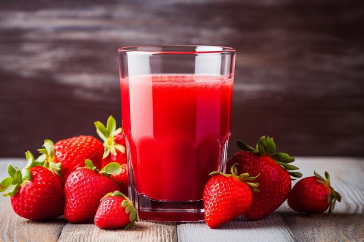 Photo un verre de jus de fraise avec une cuiller et une cuillère à côté