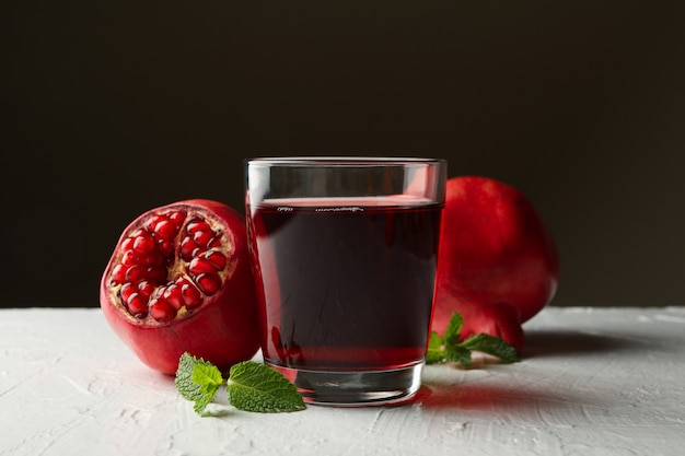 Verre de jus de grenade frais sur tableau blanc