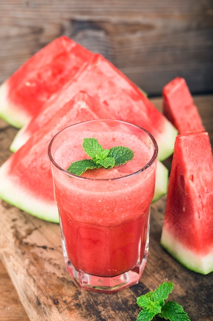 Photo un verre de jus de melon d'eau fraîche sur un fond de planche de bois